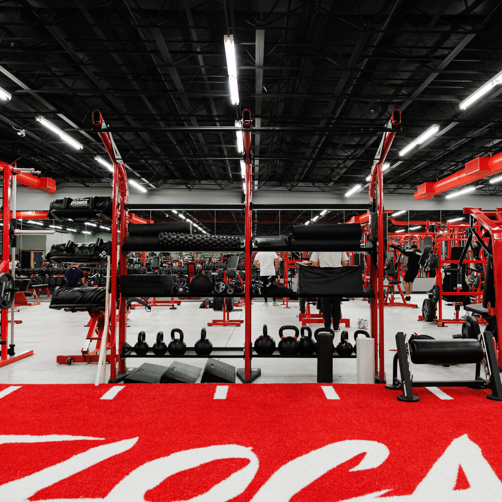 Rack row with kettlebells and the red turf runway in the foreground