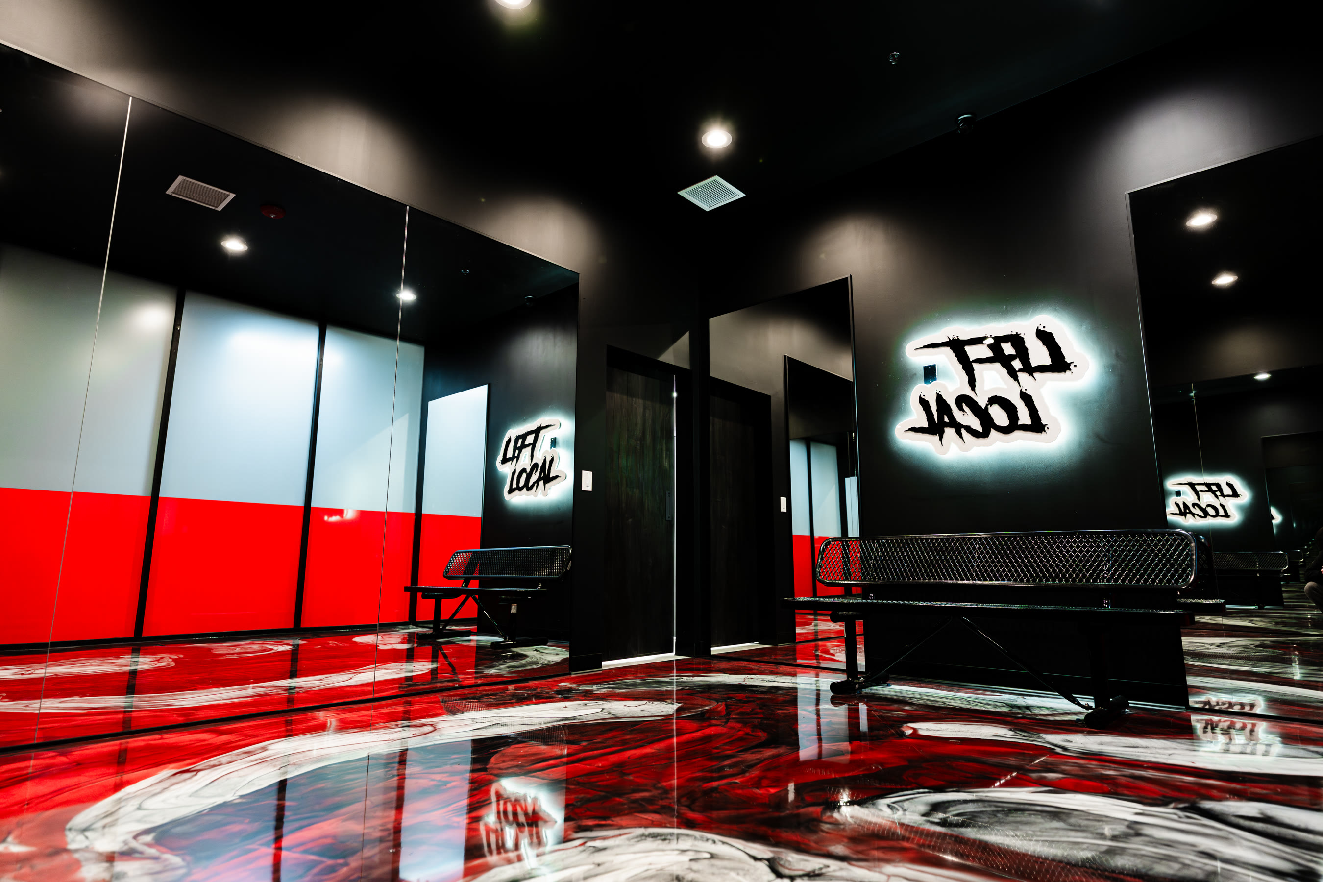 The Camarillo recovery lounge — LIFT LOCAL neon sign glowing over the black room and red epoxy floor