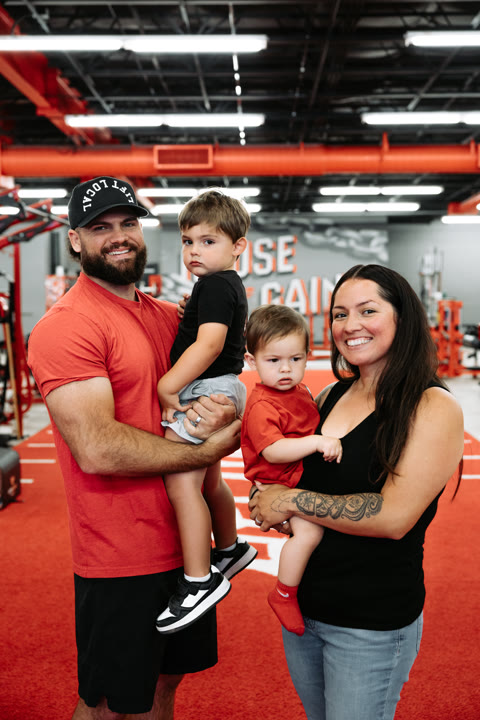 David and Victoria with their two kids on the red turf — the House of Gains founding family