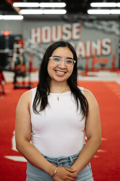 Gabby, of the House of Gains Oxnard crew, on the red turf in front of the House of Gains wall