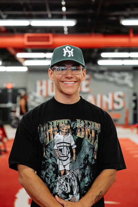 Gabe, of the House of Gains Oxnard crew, smiling on the red turf