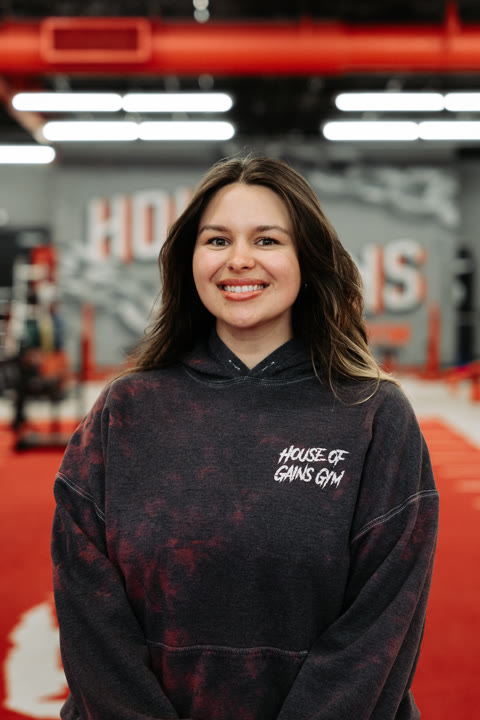 Larissa, of the House of Gains Oxnard crew, in a House of Gains hoodie on the red turf