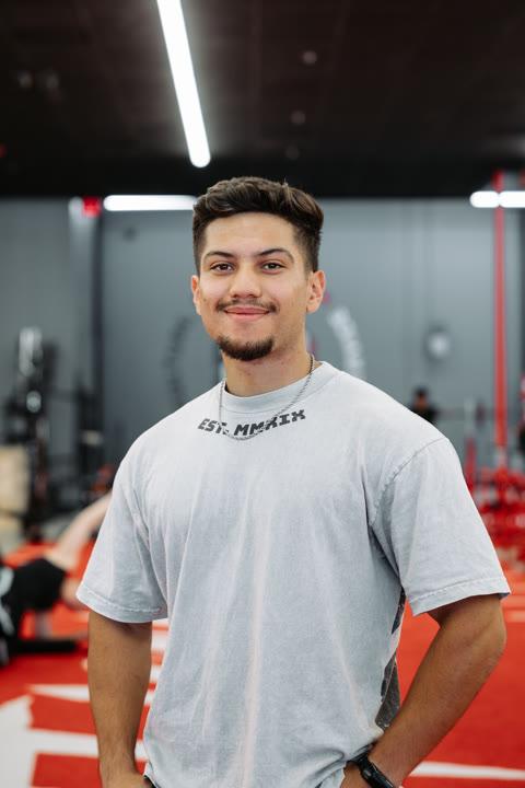 Sam, of the House of Gains crew, in an EST. MMXIX shirt on the red turf