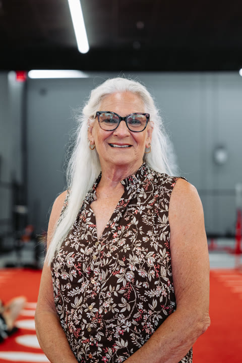 Tamah — the House of Gains gym mom — smiling on the red turf